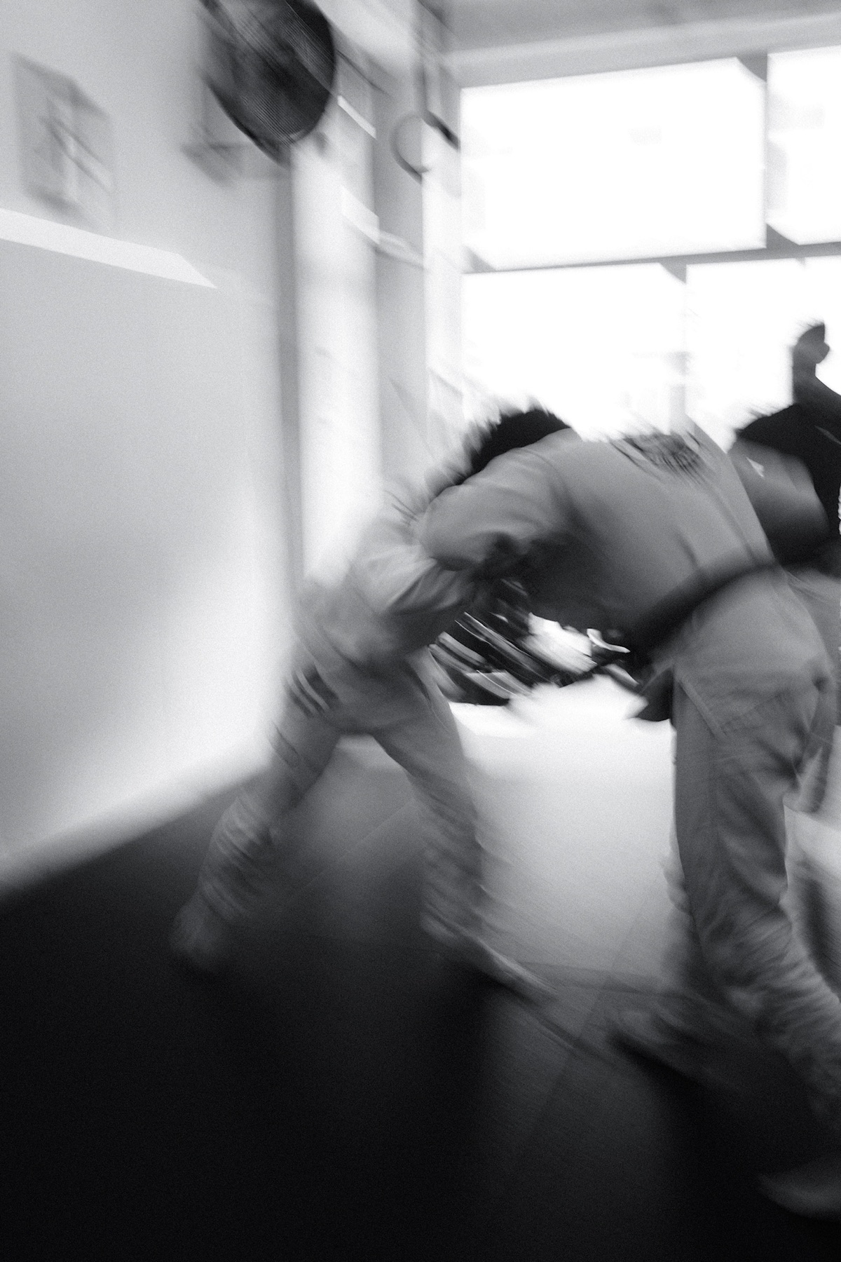 Two jiu-jitsu practitioners moving through a standing exchange